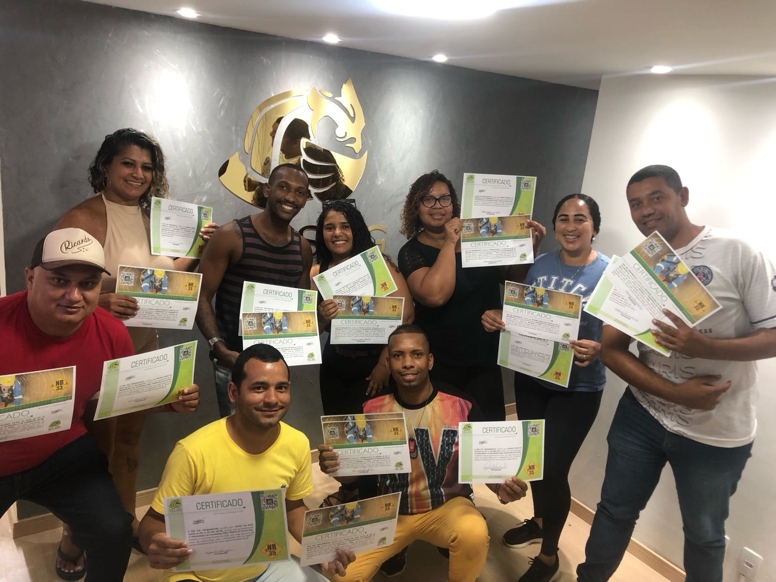 Turma de colaboradores recebendo certificados de NR-33 e NR-35 em treinamento in company